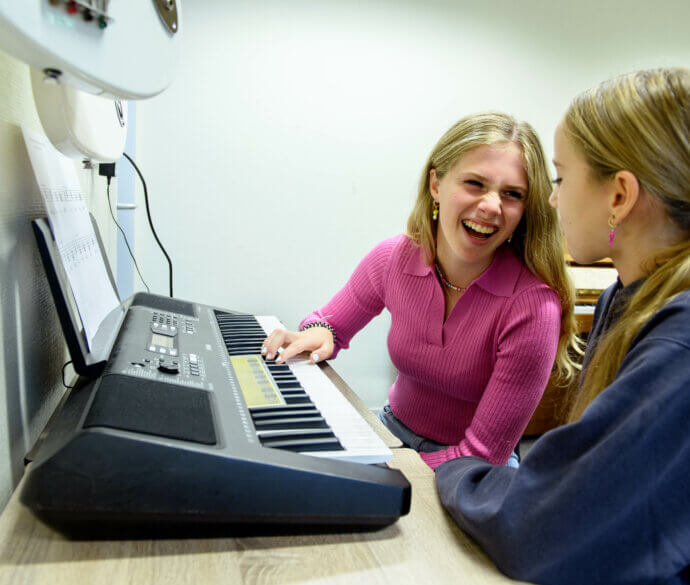 Leerlingen achter een keyboard tijdens muziekles op het Dalton College